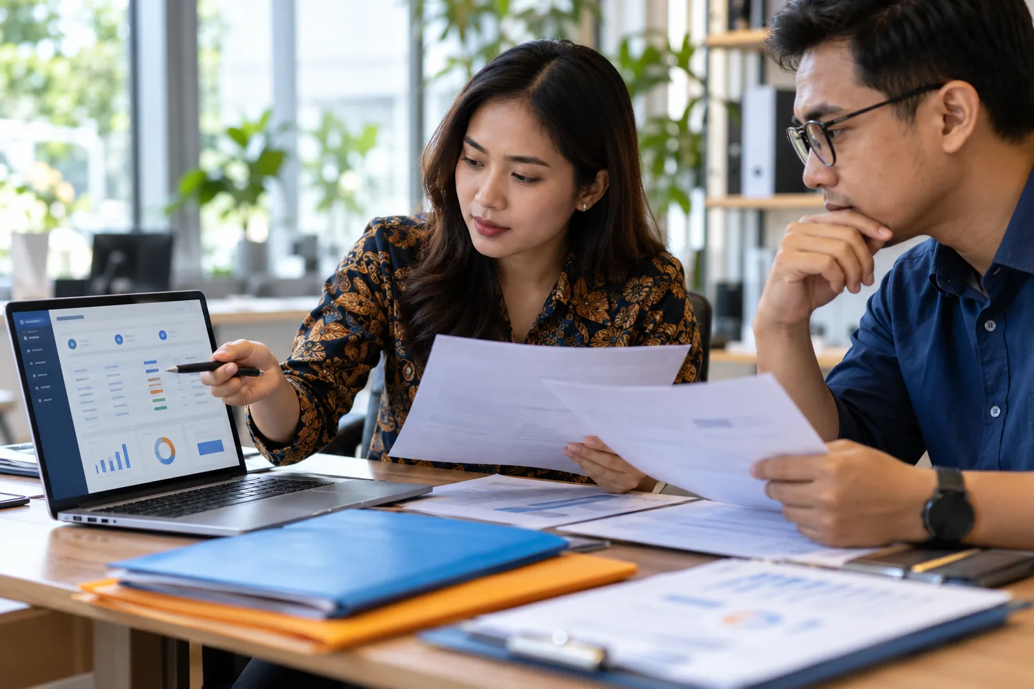 Staf legalitas perusahaan konstruksi memeriksa dokumen perizinan berusaha melalui sistem administrasi digital.